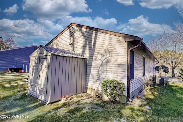 view of home's exterior featuring a lawn, central air condition unit, and a shed