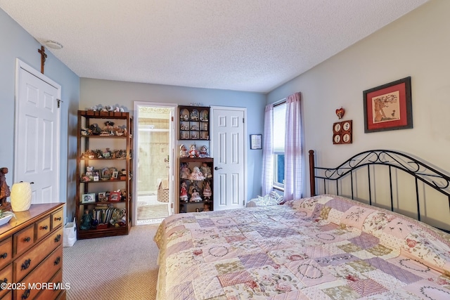 bedroom featuring ensuite bathroom, a textured ceiling, a closet, and light carpet