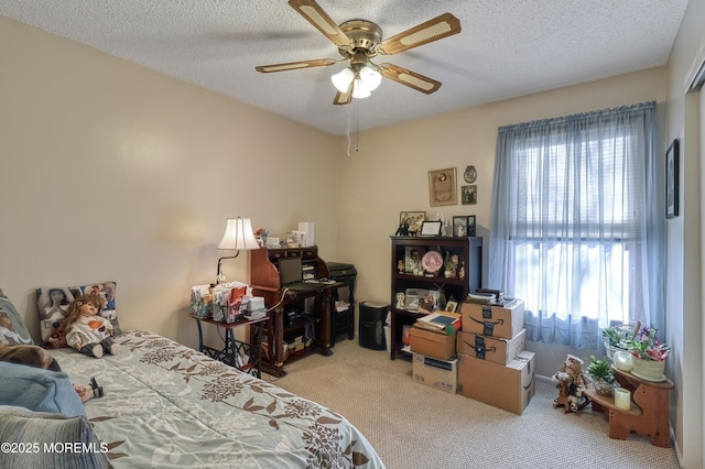 carpeted bedroom featuring multiple windows, a textured ceiling, and ceiling fan