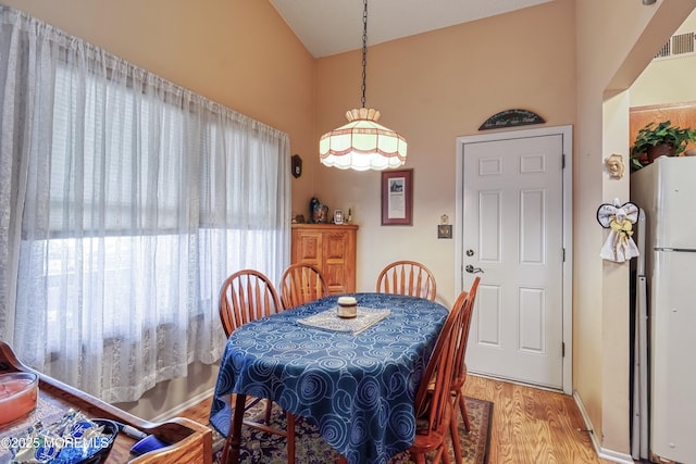 dining area with lofted ceiling and wood-type flooring