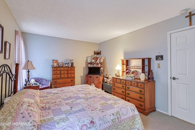 bedroom with a textured ceiling and light colored carpet