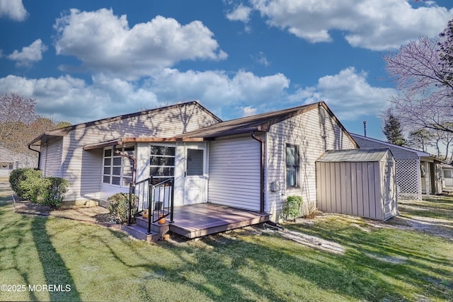 back of house with a storage shed and a lawn