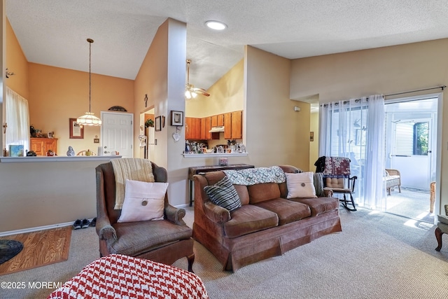 carpeted living room with high vaulted ceiling, a textured ceiling, and ceiling fan