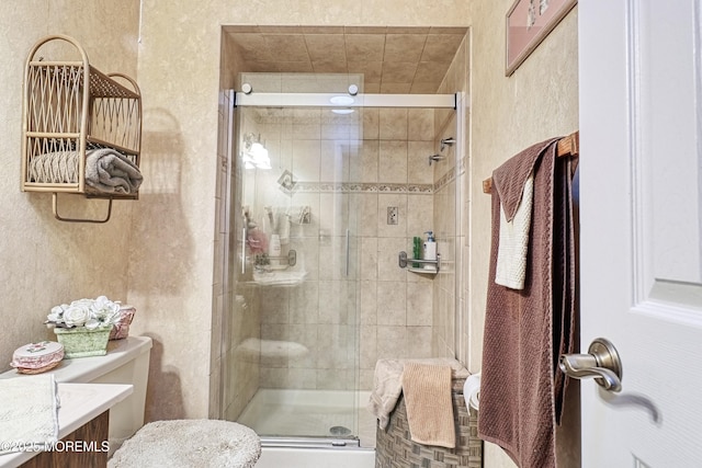 bathroom featuring toilet, an enclosed shower, and vanity