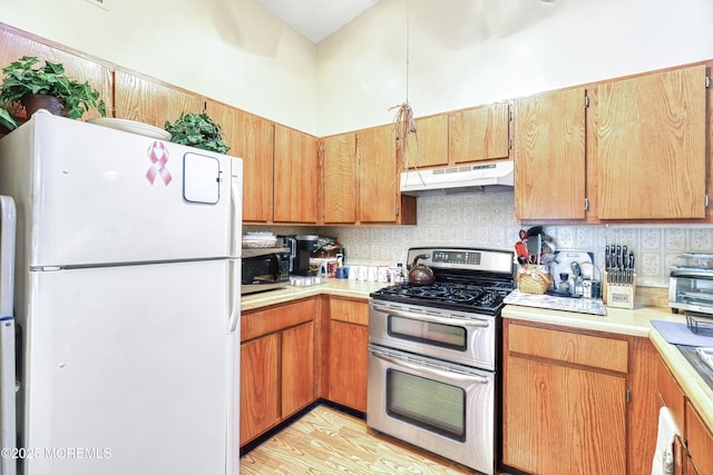 kitchen featuring stainless steel appliances, tasteful backsplash, and light hardwood / wood-style flooring