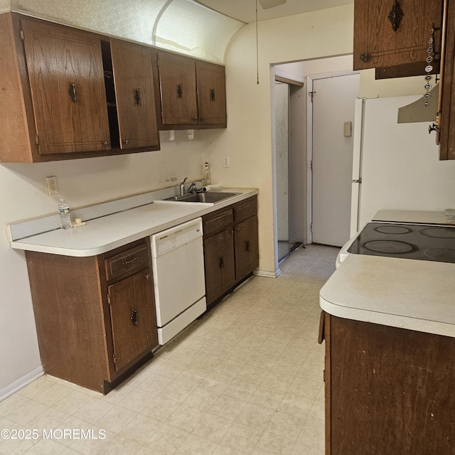 kitchen with dark brown cabinets, sink, and white appliances