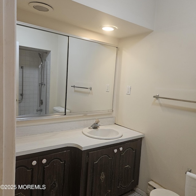 bathroom featuring tiled shower, vanity, and toilet