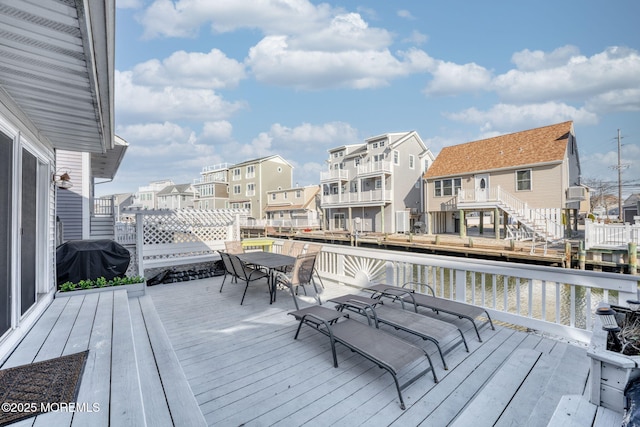 deck with grilling area and a water view