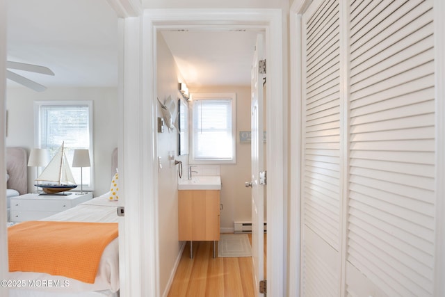 hall with light wood-type flooring and baseboard heating