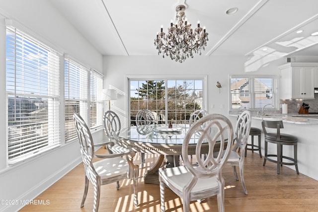 dining space with a chandelier and light hardwood / wood-style floors