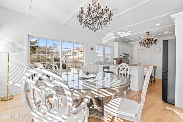 dining area with light wood-type flooring and a chandelier