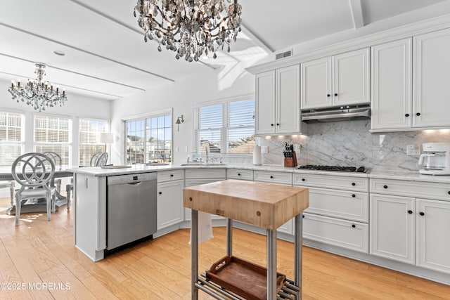 kitchen featuring a notable chandelier, appliances with stainless steel finishes, tasteful backsplash, white cabinets, and sink