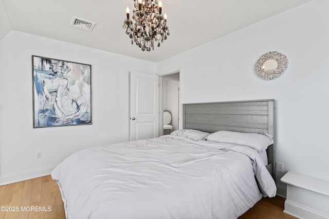 bedroom with vaulted ceiling, an inviting chandelier, and wood-type flooring