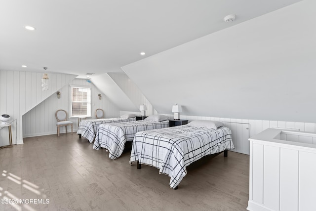 bedroom featuring wood walls, wood-type flooring, and lofted ceiling