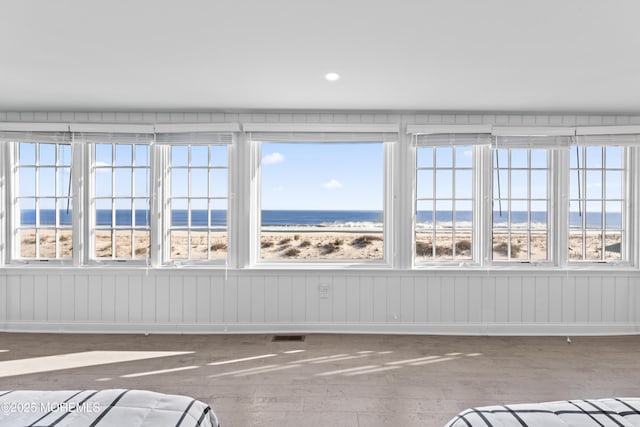 unfurnished sunroom featuring a water view