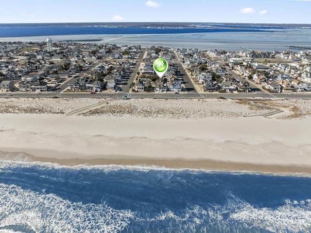 birds eye view of property featuring a water view and a beach view