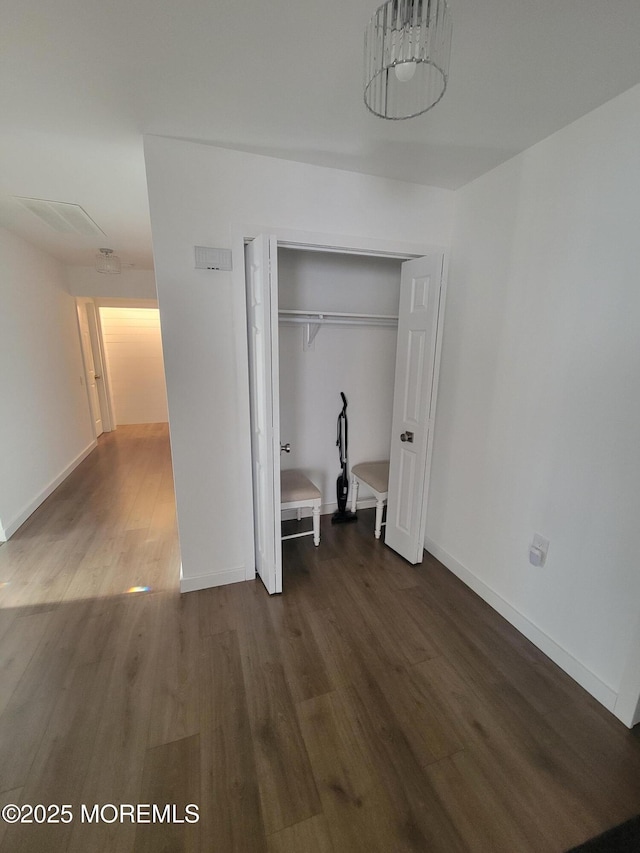 unfurnished bedroom featuring a closet and dark hardwood / wood-style floors