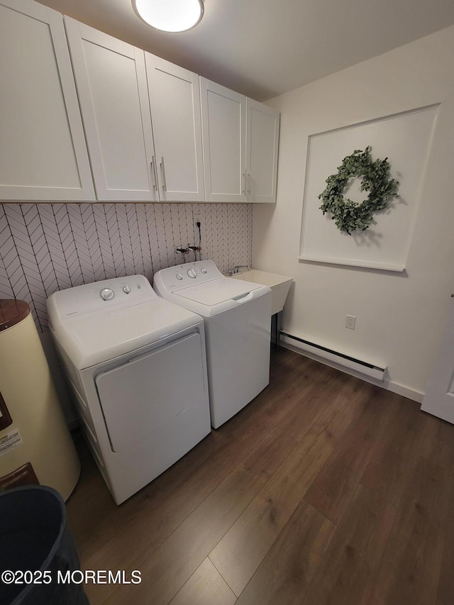 clothes washing area with baseboard heating, separate washer and dryer, cabinets, and dark wood-type flooring