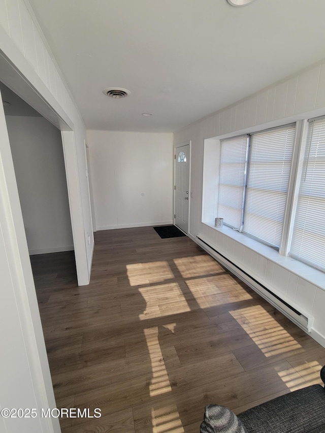 interior space featuring baseboard heating and dark hardwood / wood-style floors