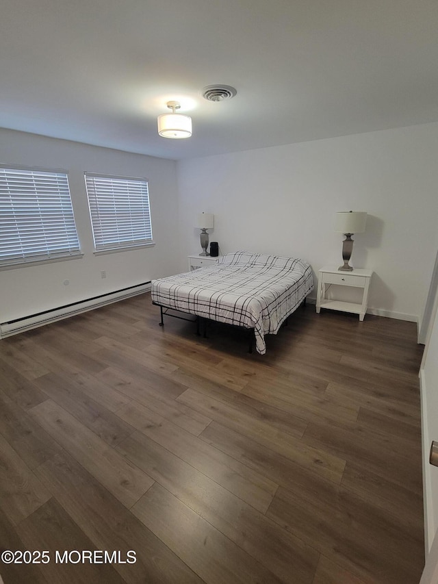 bedroom with a baseboard radiator and dark hardwood / wood-style floors