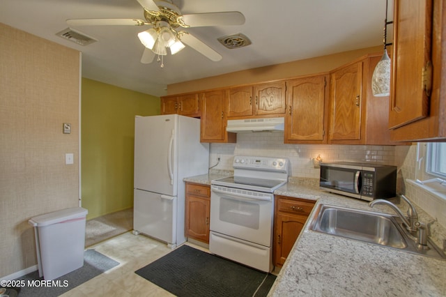 kitchen featuring backsplash, white appliances, ceiling fan, sink, and hanging light fixtures