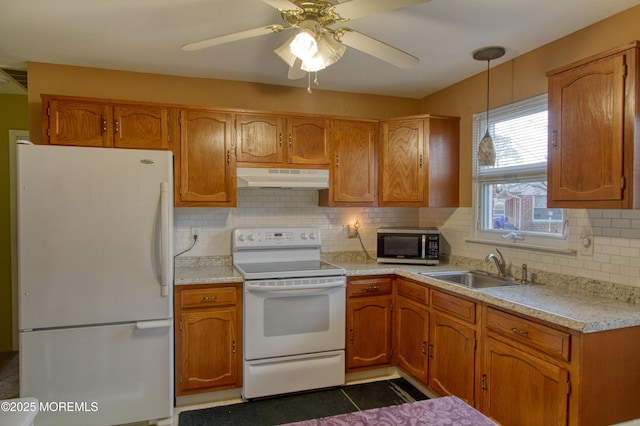 kitchen featuring tasteful backsplash, sink, hanging light fixtures, and white appliances