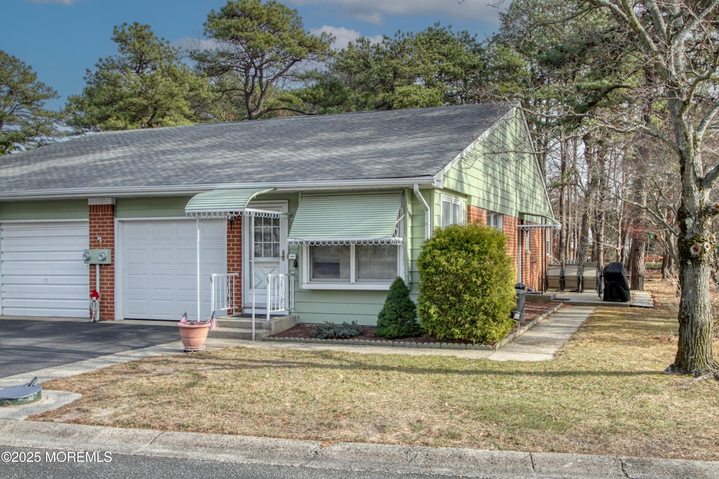 view of front of house with a garage and a front lawn