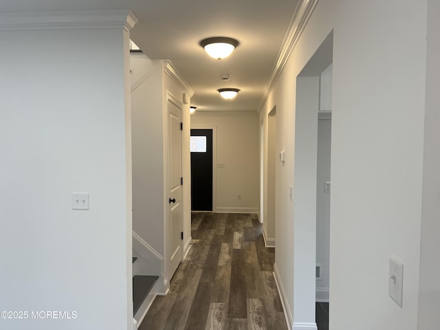 corridor with ornamental molding, dark wood-style flooring, and baseboards