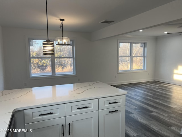 kitchen with open floor plan, dark wood finished floors, white cabinetry, and light stone countertops