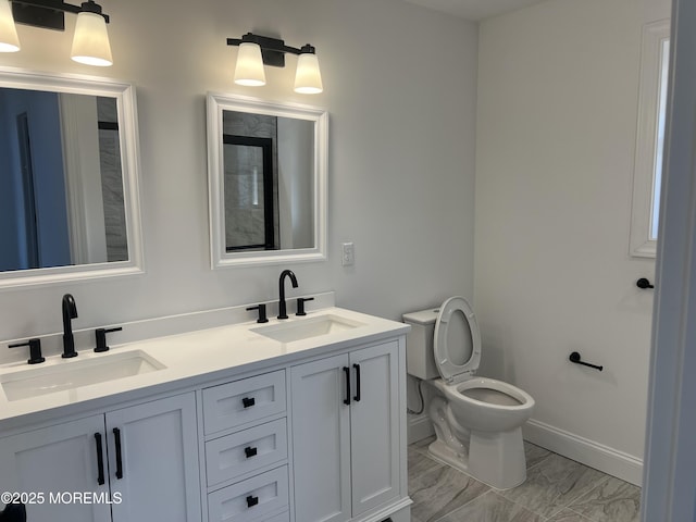 full bathroom featuring marble finish floor, double vanity, a sink, and toilet