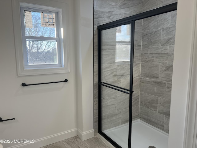 bathroom with a stall shower and baseboards