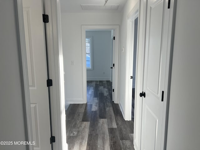 corridor with dark wood finished floors and baseboards