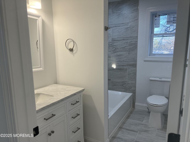 full bathroom featuring toilet, marble finish floor, baseboards, and vanity