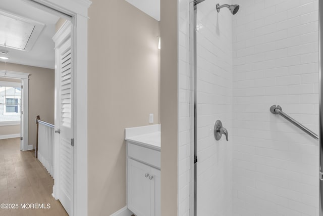 bathroom with vanity, hardwood / wood-style flooring, and a tile shower