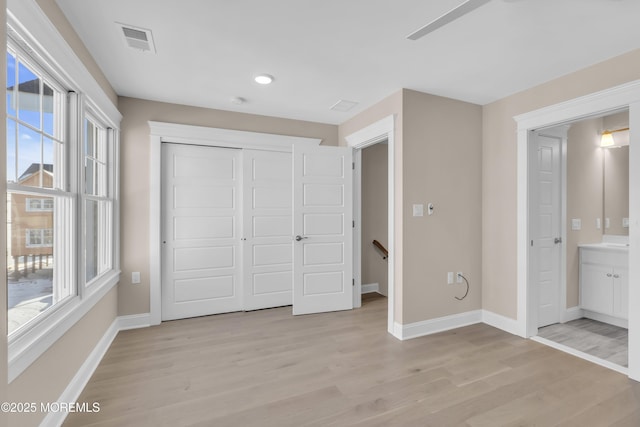 unfurnished bedroom featuring light hardwood / wood-style floors and a closet