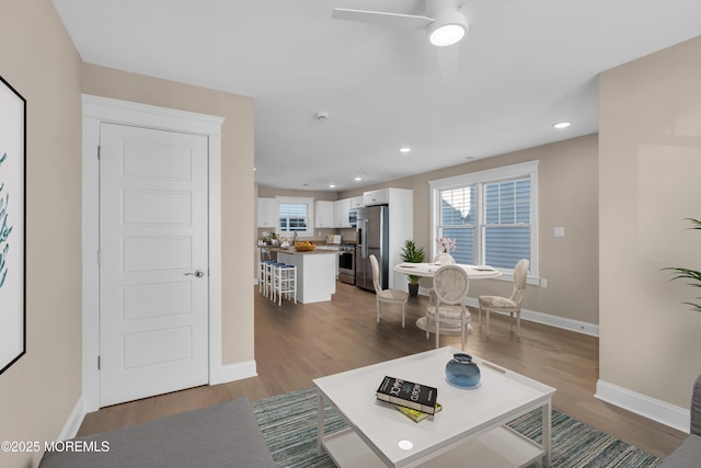 living room with hardwood / wood-style flooring, a healthy amount of sunlight, and ceiling fan