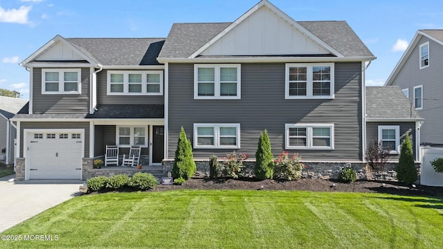 view of front facade with covered porch, a garage, and a front yard