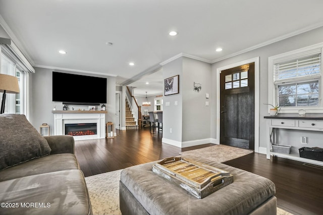 living room with hardwood / wood-style flooring, a notable chandelier, and crown molding