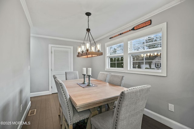 dining room with dark hardwood / wood-style floors and crown molding