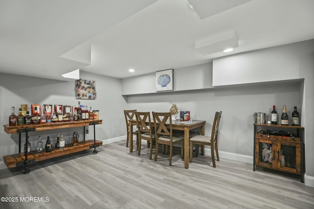 dining area featuring light hardwood / wood-style floors and bar