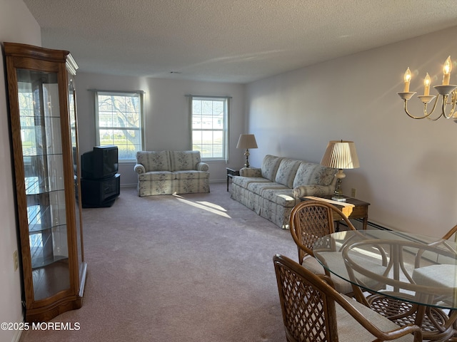 living room featuring carpet, a textured ceiling, and a notable chandelier