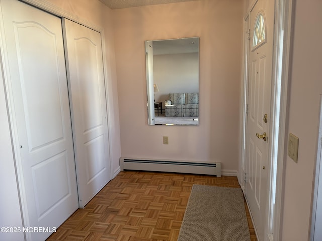 entryway with light parquet flooring and a baseboard heating unit