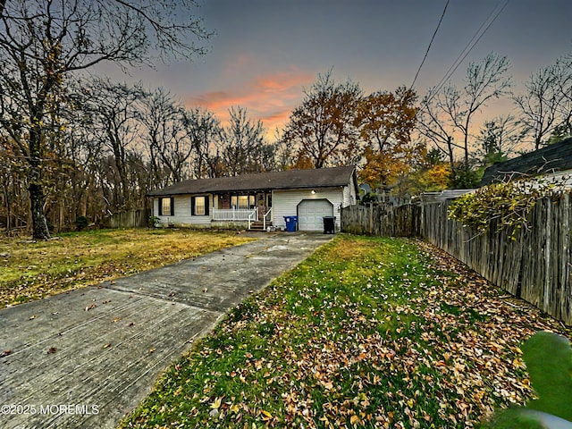 ranch-style house featuring a garage and a yard