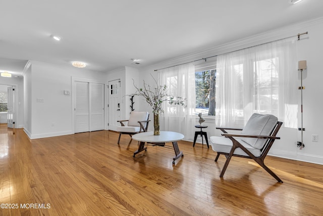 sitting room featuring light wood-type flooring and ornamental molding