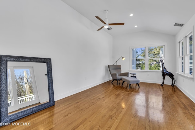 living area with ceiling fan, light hardwood / wood-style flooring, and lofted ceiling