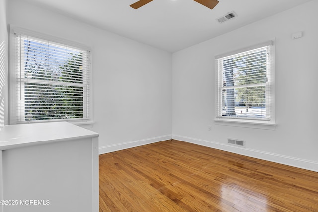 unfurnished room with ceiling fan and hardwood / wood-style flooring