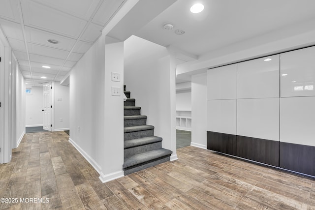 staircase with hardwood / wood-style floors and built in features