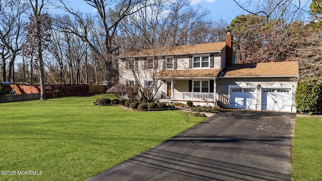 view of front of house featuring covered porch, a front yard, and a garage