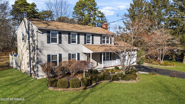 colonial-style house with a porch and a front yard