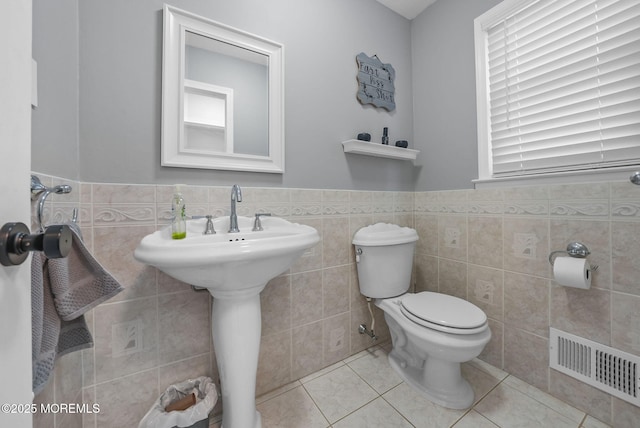 bathroom with tile patterned floors, tile walls, and toilet